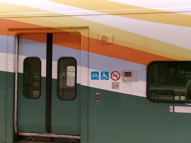 Three decals on the side of one of the entrances to a SunRail Bombardier Bi-Level passenger car at the DeLand Amtrak and SunRail station in West DeLand, Florida . The first logo tells cyclists they can store their bicycles on the cars. The second tells people that the car is ADA compliant for passen. Planning a car-free cycling weekend around Amtrak bike roll-on routes